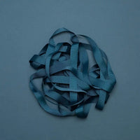 Ripsband-Breite-16mm-laenge-5m-Farbe-Petroblau-Ausgerollt-auf-farbigen-untergrund-Produktansicht-1